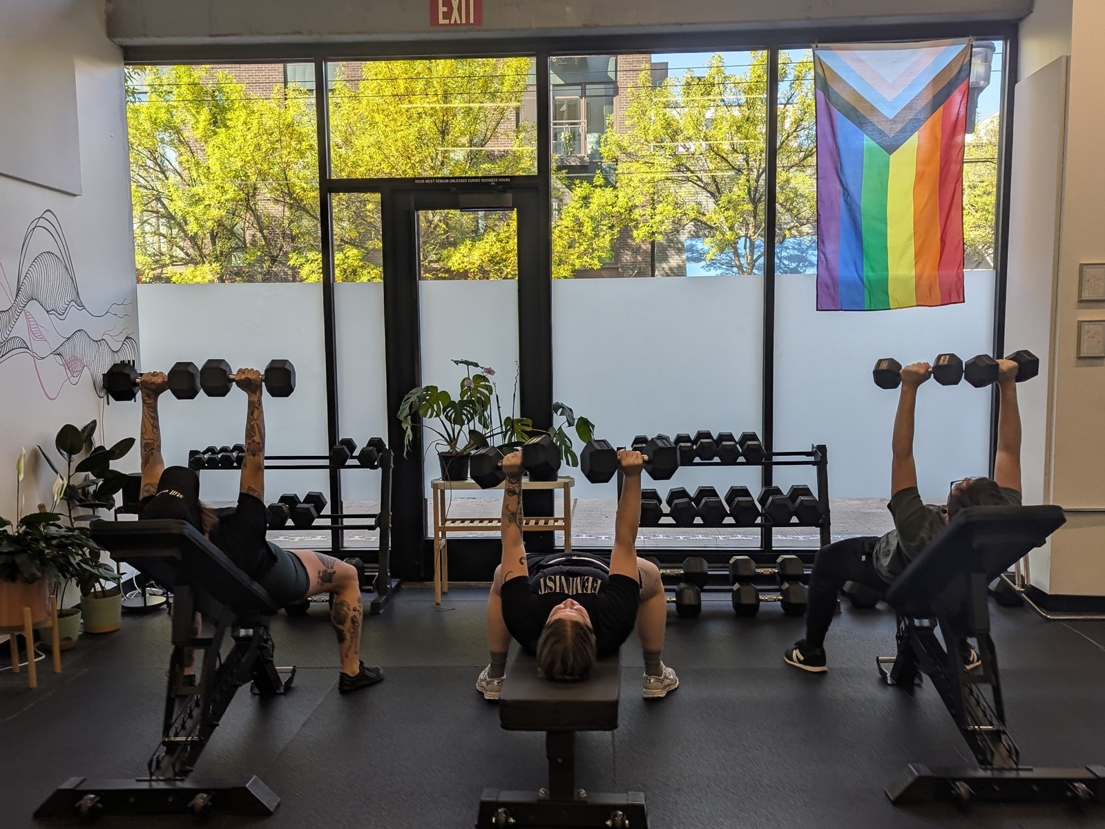 Beginners receiving personal training guidance at Uplift Fitness in Seattle, learning proper strength training techniques in a welcoming gym environment.